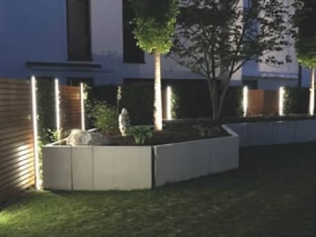 Holz-Sichtschutz mit vertikaler Beleuchtung hinter Beton-L Steinen