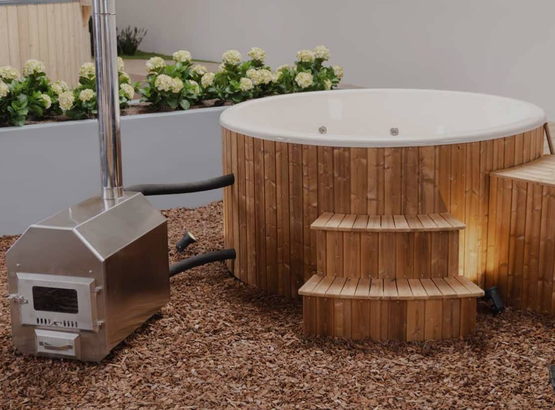 Runder Hot Tub im Holzdesign mit einem silbernen Ofen links davon