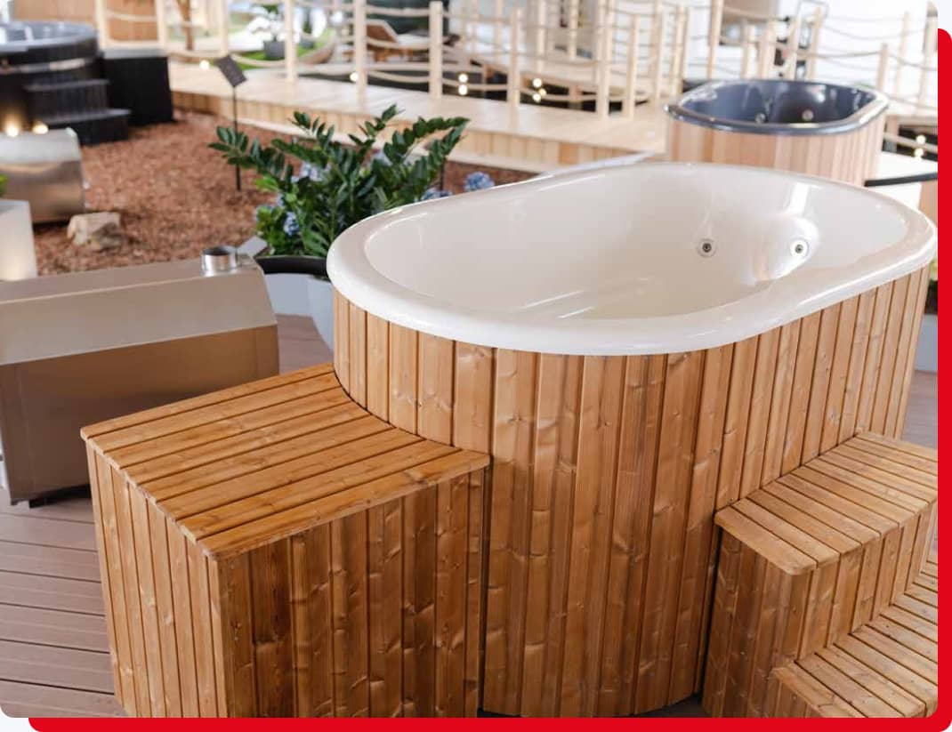 Ovaler Hot Tub in einer Ausstellungshalle mit Holzstufen für den Einstieg